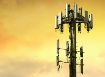 A cell phone tower with many antennas on it.